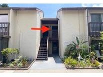 Condo entrance with stairs leading to the unit and well-maintained landscaping at 2636 Hidden Lake N Dr # G, Sarasota, FL 34237