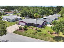 Aerial view of a purple single-Gathering home with a large yard, pool and screened-in porch, surrounded by lush trees at 3240 6Th St, Sarasota, FL 34237