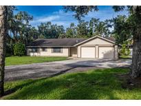 Charming single-story home featuring an attached two-car garage and a long driveway, surrounded by mature trees at 3804 65Th E St, Bradenton, FL 34208