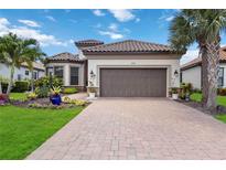Beautiful front exterior of home with a tile roof, two-car garage, and beautifully landscaped front yard at 4540 Terrazza Ct, Bradenton, FL 34211