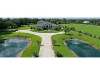 Expansive estate featuring a circular driveway, mature landscaping, and serene ponds with fountains at 520 Rye Ne Rd, Bradenton, FL 34212