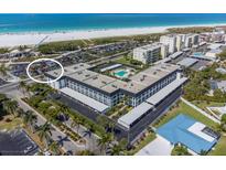 Stunning aerial view of the condo complex with a pool and beach access in a tropical community at 5600 Beach Way Dr # 315, Sarasota, FL 34242