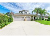 Beautiful two-story home boasts a three-car garage, a basketball hoop and well manicured landscaping with mature palm trees at 6423 Royal Tern Cir, Lakewood Ranch, FL 34202