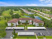 An aerial view of a condo community featuring well-maintained landscaping, a pond, and access to a nearby golf course at 6507 Stone River Rd # 304, Bradenton, FL 34203
