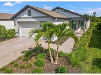 Charming single-story home with a two-car garage, manicured lawn, and inviting front entrance at 6563 Silverstar Dr, Sarasota, FL 34240