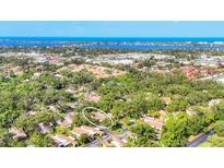 Stunning aerial view of home nestled among lush greenery with a picturesque waterfront backdrop at 6832 Woodwind Dr # 53, Sarasota, FL 34231