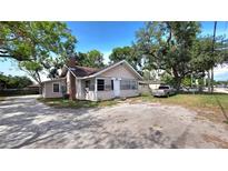 Charming single-Gathering home with ample parking and a quaint front porch nestled beneath lush, mature trees at 809 30Th E Ave, Bradenton, FL 34208