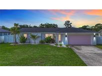 Charming single-story home with a well-manicured lawn, pink garage door, and tasteful landscaping at 912 Ponderosa Pine Ln, Sarasota, FL 34243