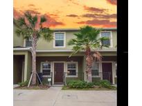 Townhome exterior showcasing tropical landscaping including palm trees at 1426 Harbour Blue St, Ruskin, FL 33570
