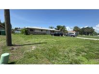Charming single-story home with a well-maintained lawn and a stone facade and driveway at 23067 Elmira Blvd, Punta Gorda, FL 33980