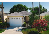 Charming single-story home with well-manicured lawn, mature landscaping, and attached two-car garage at 2511 Lantana Ln, Palmetto, FL 34221