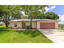 Charming single-story home featuring a well-maintained lawn, mature trees, and a two-car garage at 26147 L And J Rd, Myakka City, FL 34251