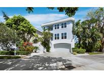 Beautiful two-story waterfront home with a driveway and lush landscaping at 3959 Somerset Dr, Sarasota, FL 34242