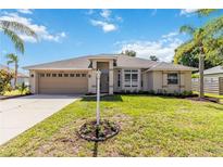 Charming single-story home with a well-maintained lawn, beautiful landscaping, and a two-car garage at 4845 Post Pointe Dr, Sarasota, FL 34233