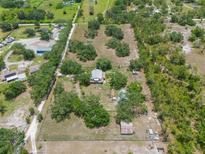 Expansive property featuring a home, outbuildings, and surrounded by mature trees and lush greenery at 5034 257Th E St, Myakka City, FL 34251