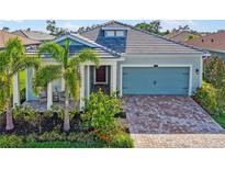 Beautiful single Gathering home with lush landscaping and a brick driveway leading to the two car garage at 5750 Long Shore Loop, Sarasota, FL 34238