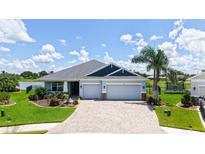 Beautiful single-story home with a two-car garage, paver driveway, and well-manicured landscaping at 5910 Hevena Ct, Palmetto, FL 34221