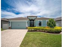 Charming single-story home with a manicured lawn, neatly trimmed bushes, and a light blue exterior paint at 6619 35Th E Ct, Sarasota, FL 34243