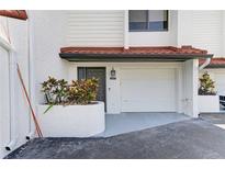 Charming condo featuring an attached garage, white stucco, and a red tile roof, surrounded by well-maintained landscaping at 6840 Midnight Pass Rd # 6840, Sarasota, FL 34242