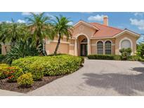 Charming home featuring a tile roof, lush landscaping and a brick-paved driveway at 6851 Bay Hill Dr, Lakewood Ranch, FL 34202