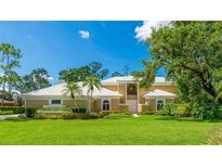 Stunning home featuring a well-manicured lawn and tropical landscaping, creating an inviting curb appeal at 7404 Weeping Willow Blvd, Sarasota, FL 34241
