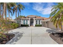 Charming single-story home with a spacious driveway, lush landscaping, and a terracotta tile roof at 8102 Waterview Blvd, Lakewood Ranch, FL 34202