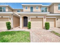Two-story townhome with a one car garage, charming entrance, and well-maintained landscaping at 8417 Karpeal Dr # 4, Sarasota, FL 34238