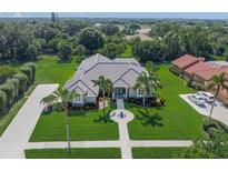 Stunning aerial view of a landscaped property featuring a well-manicured lawn and beautiful surroundings at 8924 Misty Creek Dr, Sarasota, FL 34241
