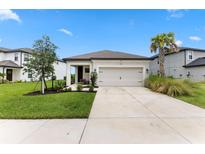 Charming one-story home with a well-manicured lawn, palm tree, neutral paint, and attached two car garage at 9012 Tequila Sunrise Dr, Sarasota, FL 34241