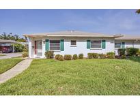 Charming single-story home with white exterior, green shutters, and a well-manicured lawn in a tranquil neighborhood at 1060 Cockrill St # 1060, Venice, FL 34285