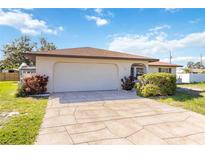 Charming single-story home featuring a wide driveway and attached two-car garage with decorative shrubs at 1163 Nantucket Rd, Venice, FL 34293