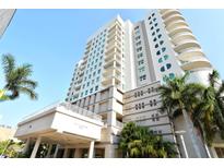 Contemporary high rise condo building exterior featuring a well-manicured entrance and multiple balconies with palm trees at 1771 Ringling Blvd # 1206, Sarasota, FL 34236