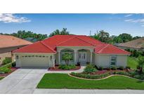 Beautiful home featuring a red tile roof, well-manicured lawn, and a two car garage at 2148 Date Palm Way, Venice, FL 34292