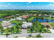 A beautiful aerial view of a neighborhood with lush landscaping and a serene pond at 303 Cockle Shell Loop, Apollo Beach, FL 33572