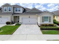 Home exterior features a two-car garage, paver driveway, manicured lawn and low maintenance landscaping at 3681 Divot Ln, Sarasota, FL 34232
