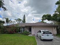 Charming single-story home with lush landscaping, a well-manicured lawn, and a private driveway at 4343 Arrow Ave, Sarasota, FL 34232