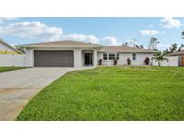 Charming single-story home with a well-maintained lawn, gray garage door, and beautiful landscaping at 4344 Bent Tree Blvd, Sarasota, FL 34241