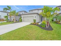 Charming home with landscaped front yard, healthy green lawn, and concrete driveway leading to a two-car garage at 5540 Summit Gln, Bradenton, FL 34203