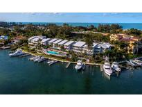 Waterfront condos with boat docks, a swimming pool, and lush landscaping offer luxurious coastal living at 615 Dream Island Pl # 105, Longboat Key, FL 34228