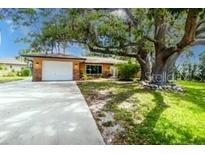 Charming single-story home with a well-maintained lawn and a large, mature tree in the front yard at 760 Azure Rd, Venice, FL 34293