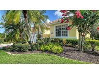Beautiful front yard features mature landscaping and a well-maintained lawn at 8183 Nice Way, Sarasota, FL 34238