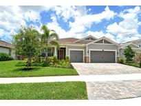 Charming single-Gathering home featuring a well-manicured lawn, mature landscaping, and a two-car garage at 8668 Sundance Loop, Sarasota, FL 34238