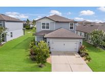 Charming two-story home features a two-car garage and a well-manicured lawn and landscaping at 8985 Royal River Cir, Parrish, FL 34219