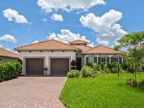 Charming single-Gathering home featuring a brick driveway and a well-maintained, vibrant green lawn at 10120 Carnoustie Pl, Bradenton, FL 34211