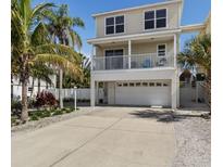 Charming two-story home featuring a spacious garage, balcony, and meticulously landscaped yard with mature palm trees at 123 52Nd St # B, Bradenton Beach, FL 34217