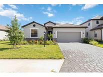 Charming single-story home with a well-manicured lawn and a paved driveway leading to a two-car garage at 15127 Oxford Grey Dr, Bradenton, FL 34211
