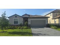 Charming one-story home featuring a manicured lawn, brick driveway, and two car garage at 15127 Oxford Grey Dr, Bradenton, FL 34211