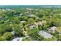 An aerial view of a charming home, nestled among lush greenery with a swimming pool and well-maintained landscaping at 2504 Mulberry Ter, Sarasota, FL 34239