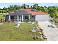 Charming single-story home featuring a red roof, solar panels, well-manicured lawn and a long driveway at 25324 Alicante Dr, Punta Gorda, FL 33955