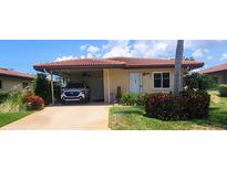 Charming single story home with a red tile roof, lush landscaping, and a convenient carport for parking at 3305 Notre Dame Pl # 3305, Bradenton, FL 34207